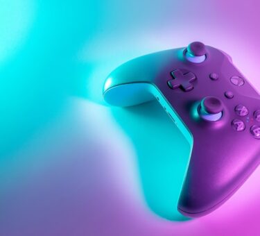 Wireless gaming controller with an Xbox-style layout lit against a colored background