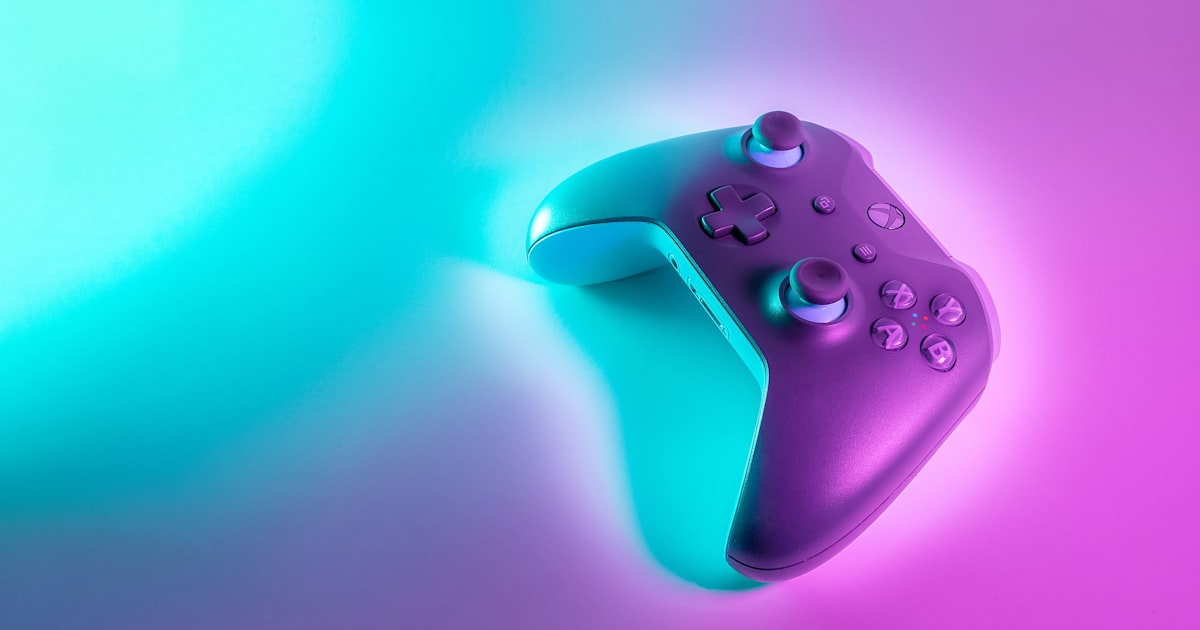 Wireless gaming controller with an Xbox-style layout lit against a colored background