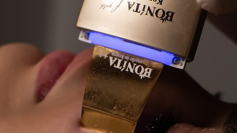 Close-up of a microcurrent face device head resting against the skin of a cheek
