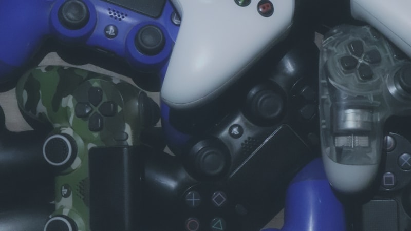 Assorted Xbox and PlayStation style gamepads piled together, showing the two main PC controller layouts