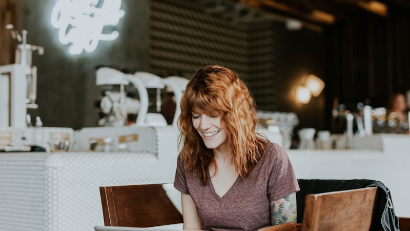 Woman using a laptop on public Wi-Fi in a coffee shop, the scenario a banking VPN is meant for