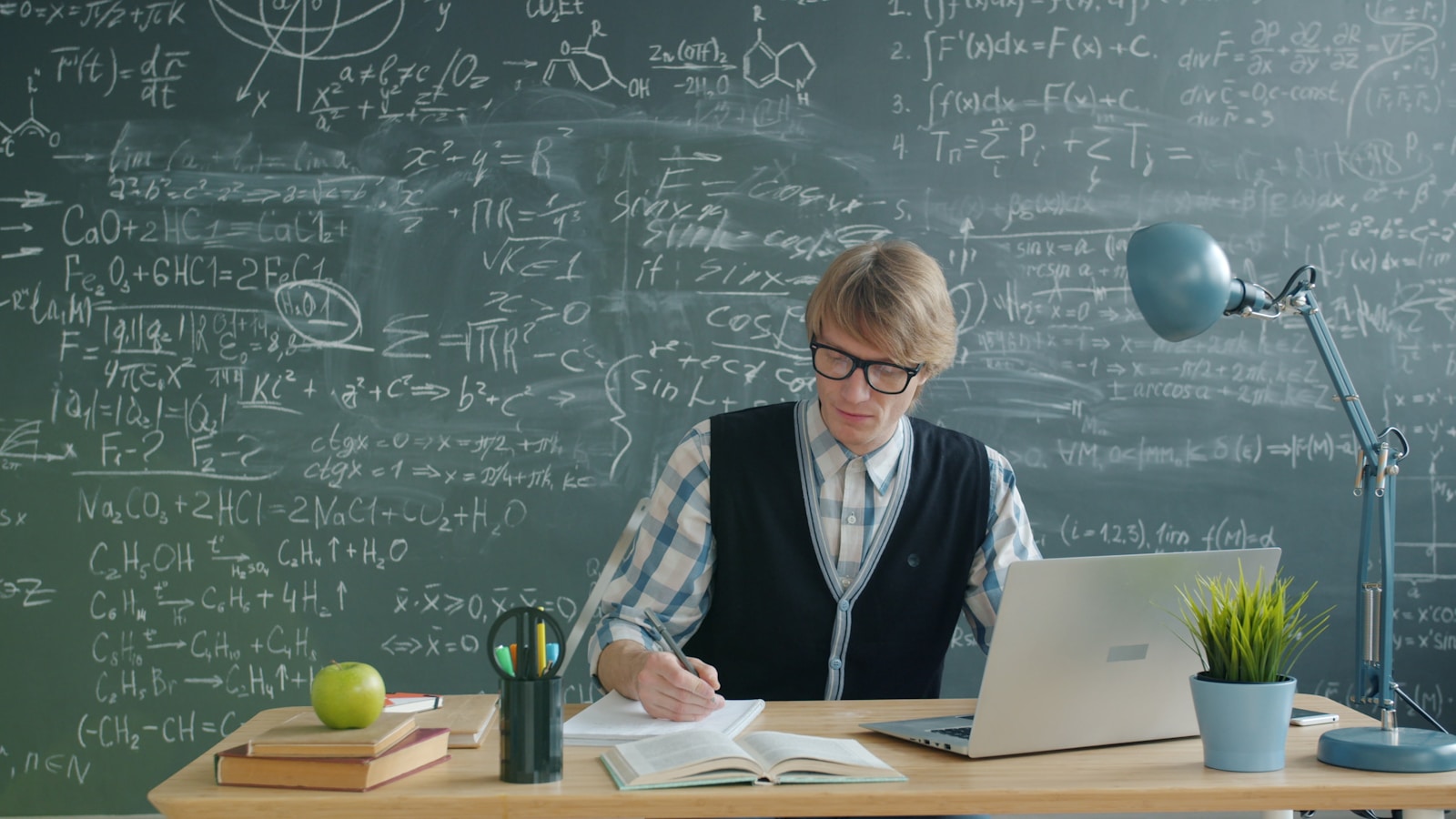 Student writing notes at a study desk