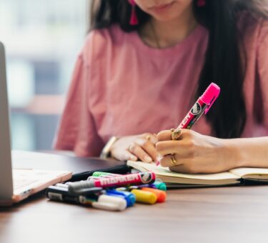 Student studying and writing notes at a desk