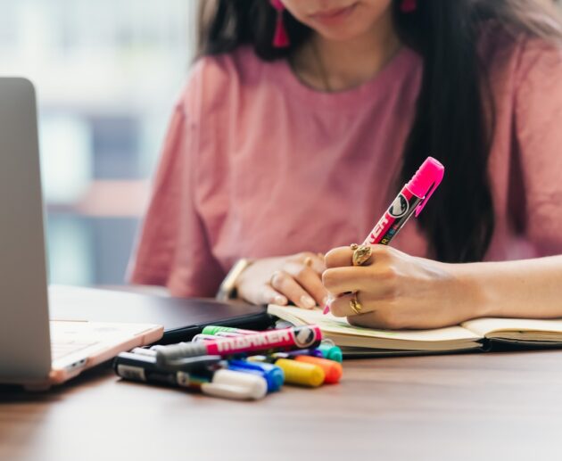 Student studying and writing notes at a desk