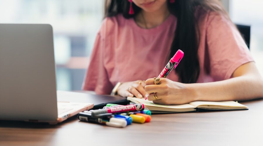 Student studying and writing notes at a desk