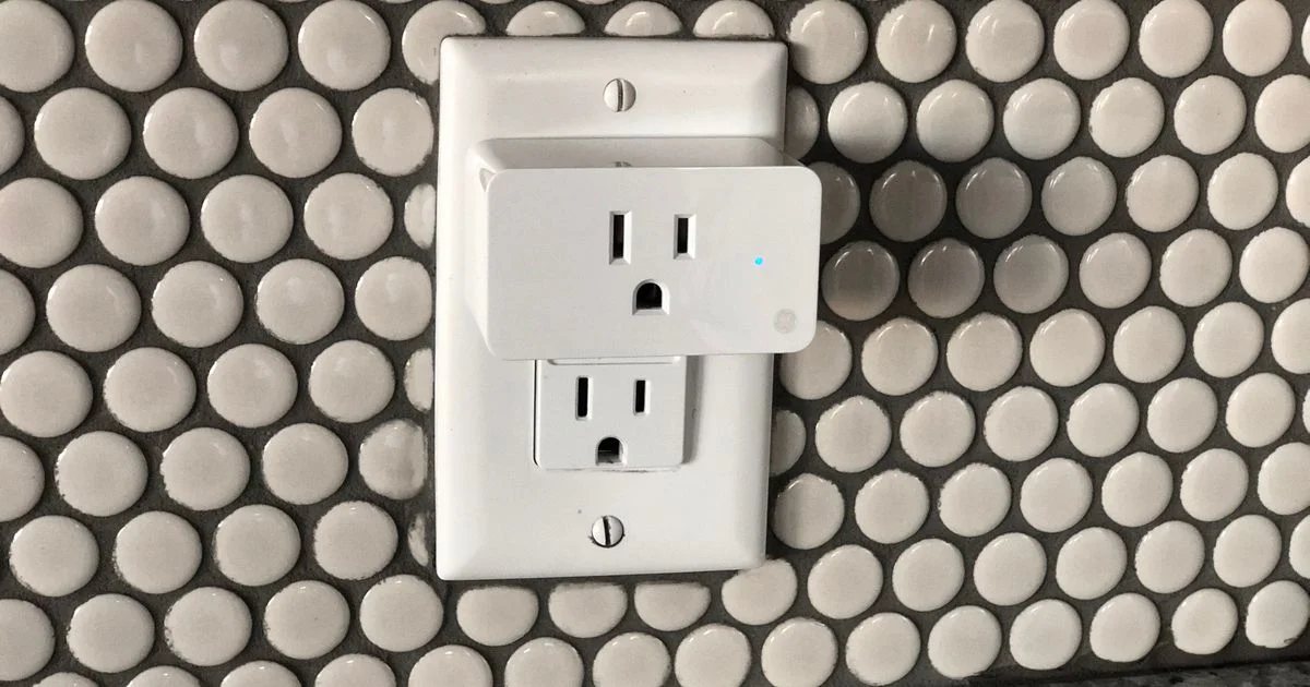 A white smart plug installed in a standard wall outlet, showing the best smart plug for home automation setups