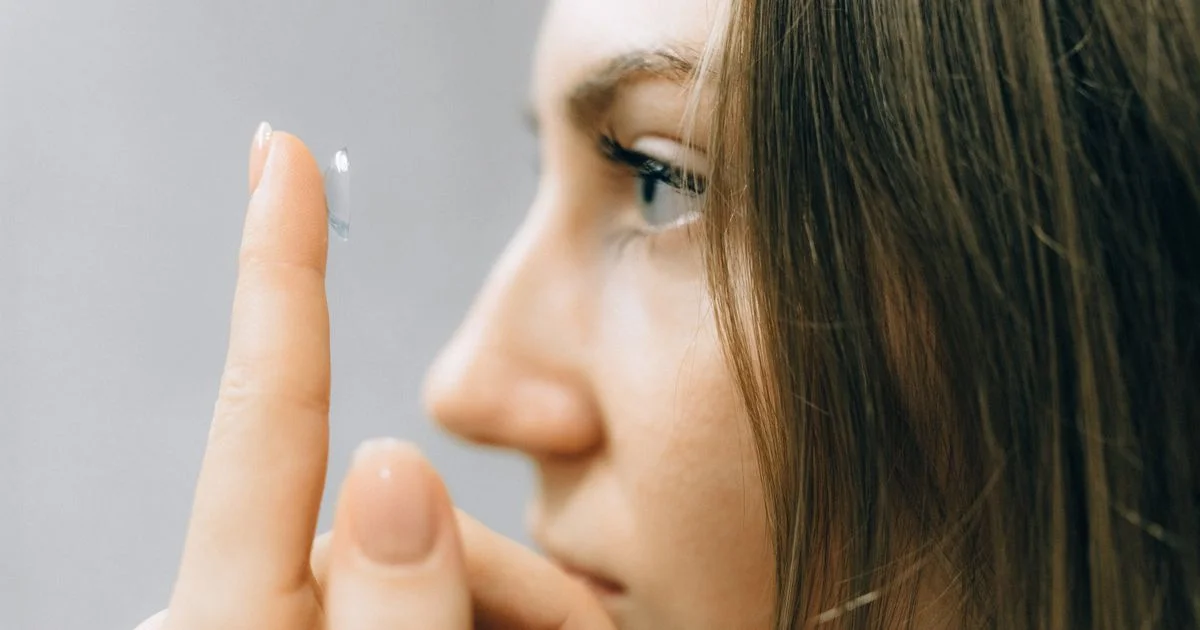 A woman balancing a soft lens on her fingertip, the morning routine behind contact lenses online for daily wear