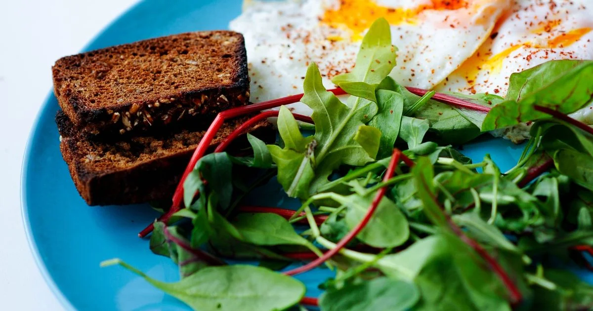 Plate of eggs, dark rye toast and leafy greens, a plate-method example of diabetic diet foods for breakfast
