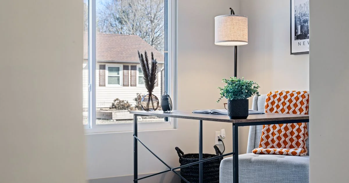 A small home office with a bare wall beside the desk, the room a smart board for the home office has to fit into