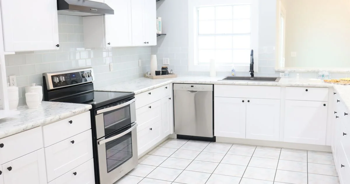 A bright kitchen with an electric range and a range hood, the room a smart smoke detector for the kitchen has to work in