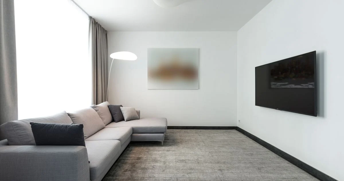 A living room sofa facing a wall-mounted television, the home setup behind choosing a sports streaming service for cord cutters