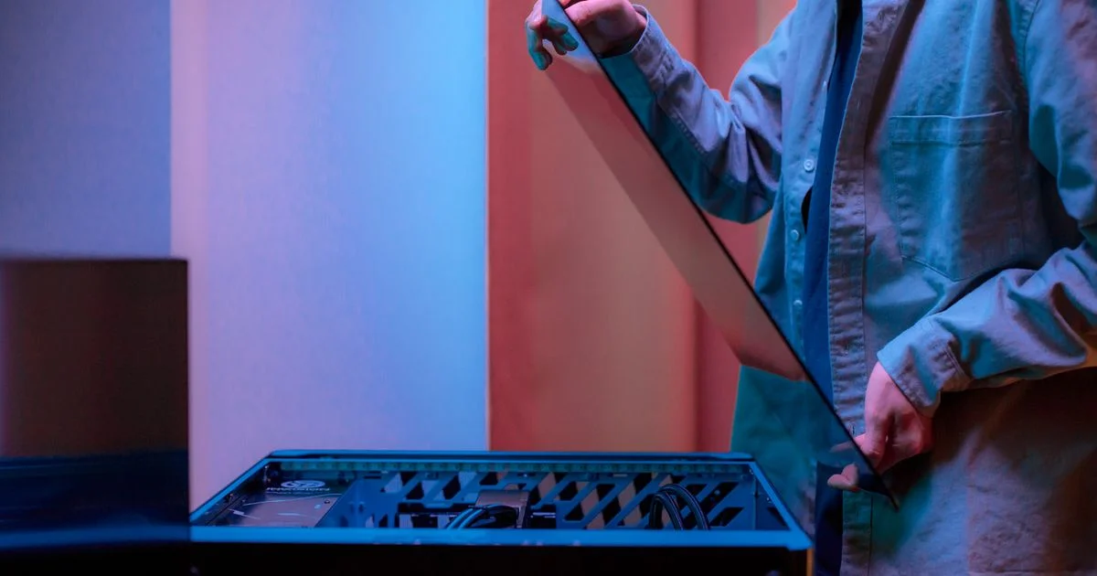 A person lowering the glass side panel back onto an open desktop tower, the job that follows fitting an SSD for gaming PCs