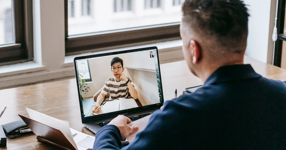 Man at a home desk on a video call beside a window, the room and lighting a webcam for streaming has to work in