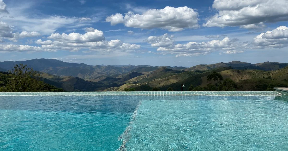 An infinity pool looking out over green hills at a resort of the kind sold in luxury vacation packages for honeymoons